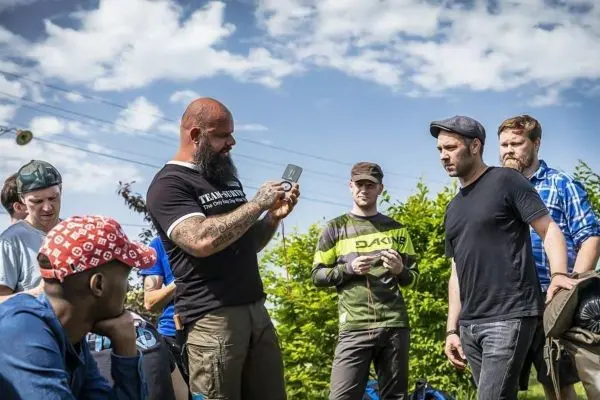 Ein Teilnehmer zeigt eine Ausrüstung an eine Gruppe von Personen im Freien