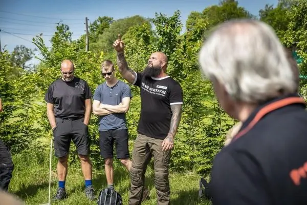 Ein Trainer erklärt eine Technik, während Teilnehmer aufmerksam zuhören