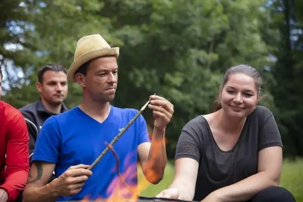 Feuerstahl erzeugt Funken auf Zunder über einem offenen Feuer