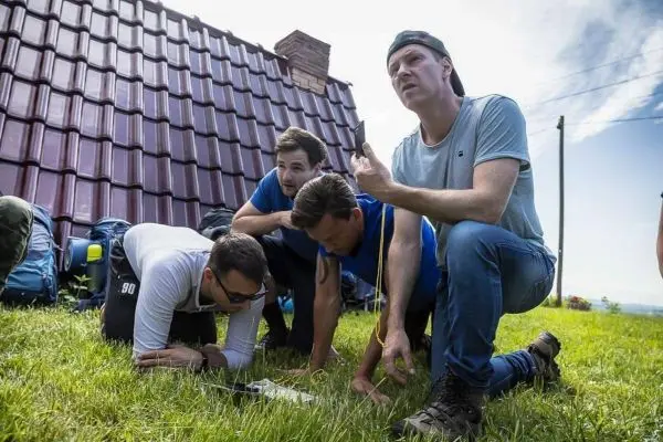 Gruppe betrachtet Karte auf dem Boden und diskutiert Orientierung