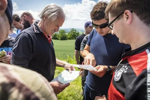 Gruppenteilnehmer studieren Kartenmaterial im Freien