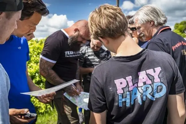 Gruppierung betrachtet Kartenmaterial und diskutiert Orientierungspunkte im Freien