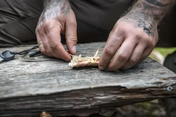 Hände bereiten Zunder auf einem Holzbrett vor