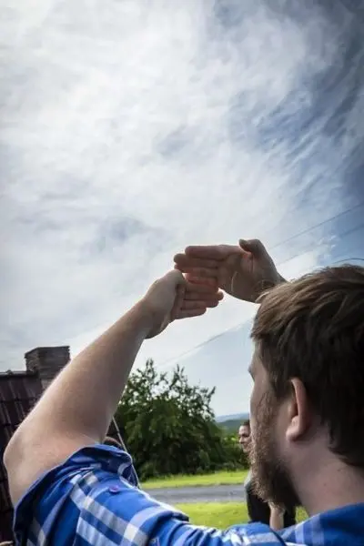 Hände formen eine Schattensilhouette gegen den Himmel