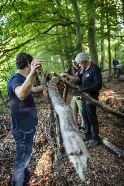 Holzstämme werden mit Schnüren zu einer Konstruktion verbunden