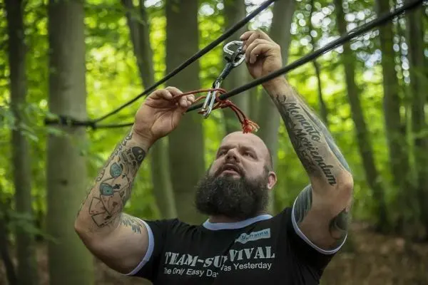 Karabiner wird an einer Seilbrücke befestigt