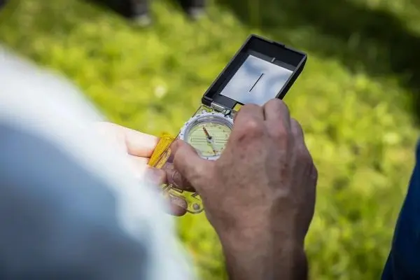 Kompass wird zur Orientierung in der Hand gehalten