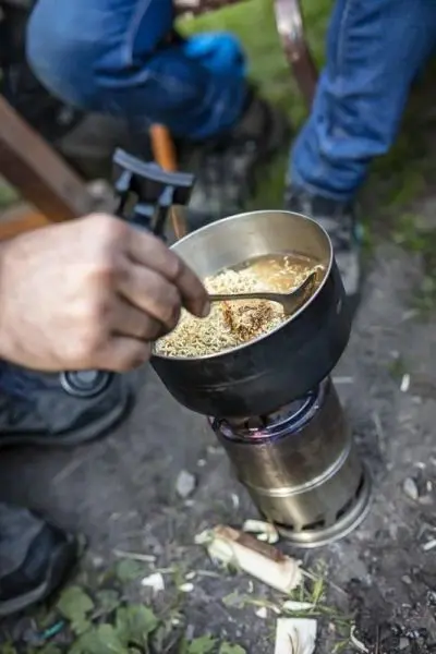 Löffel rührt in einem Topf auf einem Spirituskocher