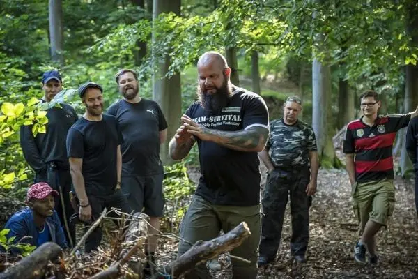 Mann demonstriert Techniken zur Holzverarbeitung in einem Waldgebiet