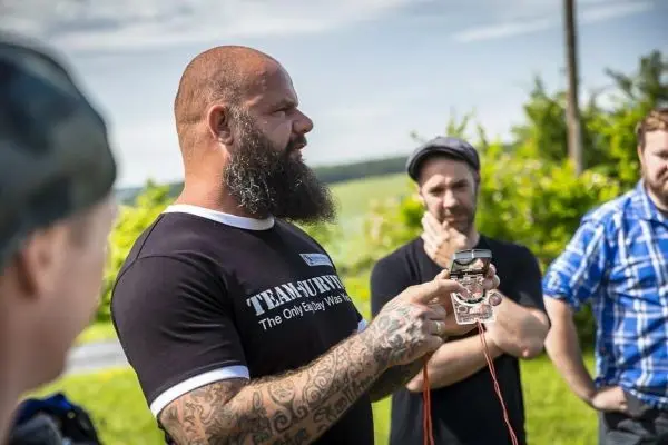 Mann erklärt eine technische Ausrüstung mit Kabeln an einer Gruppe von Zuhörern