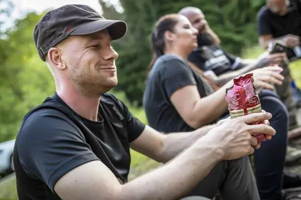 Mann hält zwei Snackverpackungen in der Hand und lächelt