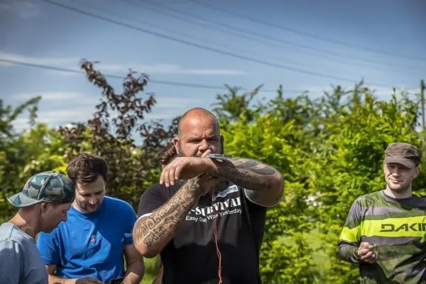 Mann mit Mikrofon erklärt Survival-Techniken, während andere zuhören