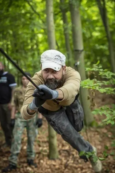 Mann schwingt an einem Seil durch den Wald