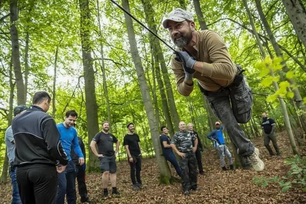 Mann schwingt an einem Seil zwischen Bäumen, um Technik zu demonstrieren