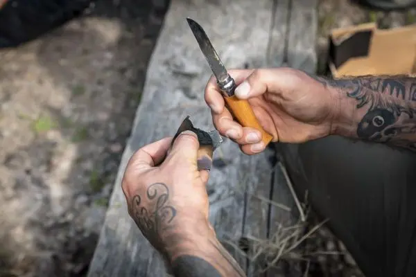Messer schneidet ein Stück Holz auf einer Holzoberfläche