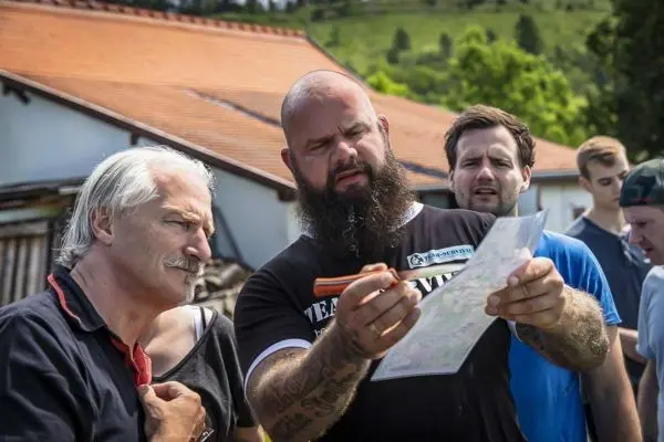 Person zeigt einer Gruppe eine Karte und erklärt etwas