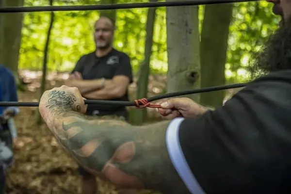 Person zieht an einem Seil im Wald
