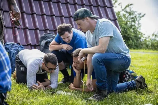 Vier Personen betrachten gemeinsam eine Karte auf dem Boden