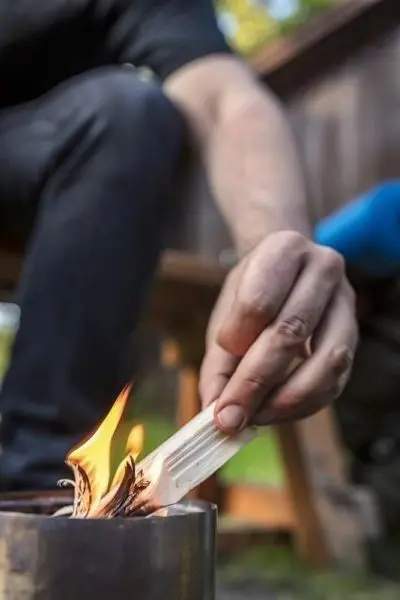 Zunder wird in ein brennendes Feuer gelegt