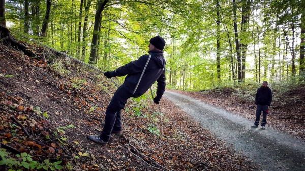 Eine Person zieht an einem Seil, während eine zweite Person zuschaut