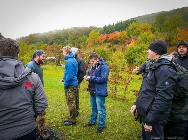 Gruppendiskussion im Freien mit verschiedenen Personen in Outdoor-Bekleidung
