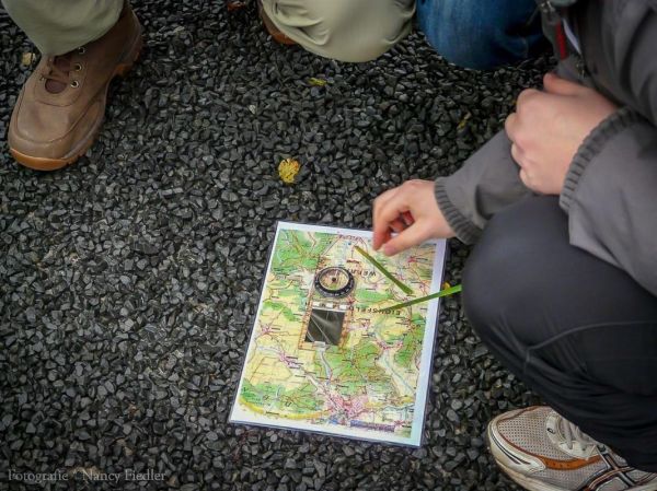 Kompass wird auf einer Karte ausgerichtet, um die Richtung zu bestimmen