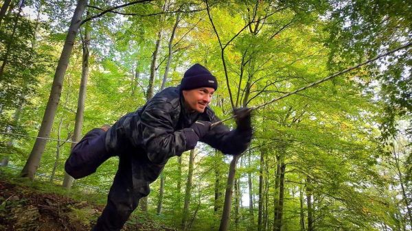 Kriechen über eine selbstgebaute Seilbrücke im Wald