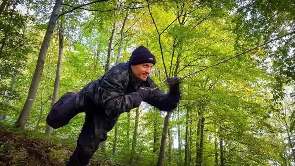 Kriechen über eine selbstgebaute Seilbrücke im Wald