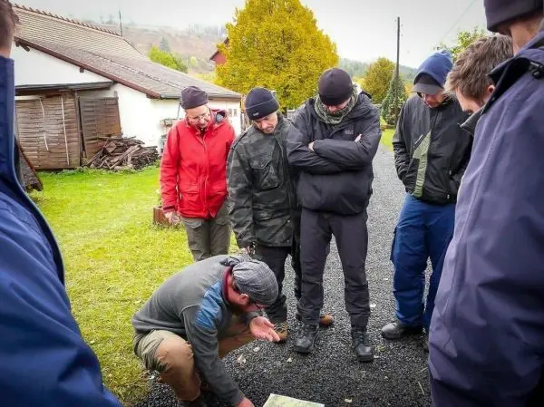 Mann erklärt Karteninformationen an interessierte Zuhörer im Freien
