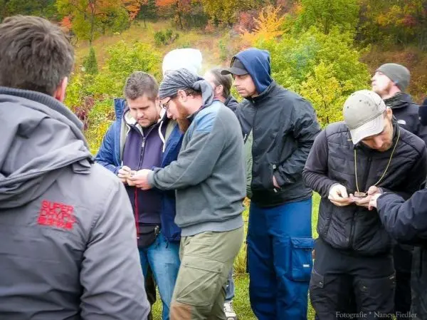 Mehrere Personen betrachten gemeinsam ein Gerät im Freien
