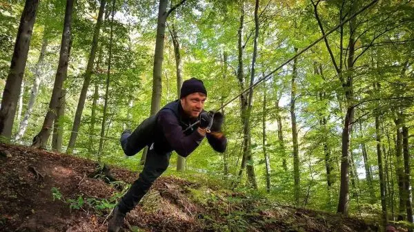 Person schwingt an einem Seil durch den Wald beim Überlebenstraining