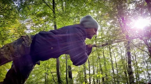 Person zieht an einem Seil im Wald