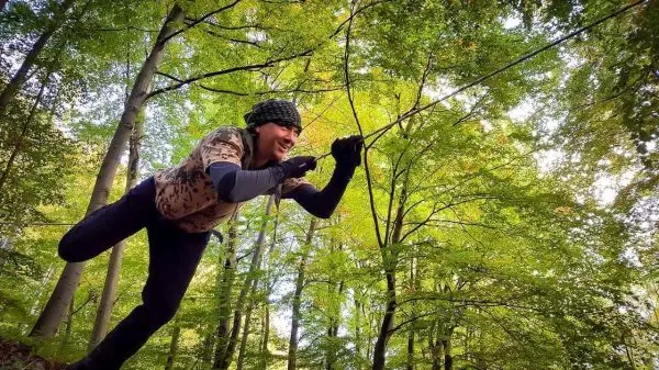 Person zieht an einem Seil in einem Waldgebiet