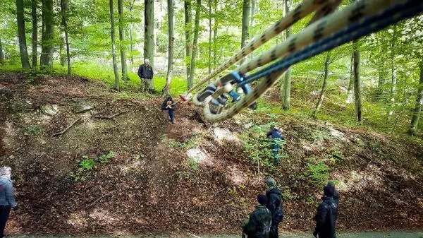 Seilbrücke wird zwischen Bäumen gespannt, Teilnehmer üben den Übertritt