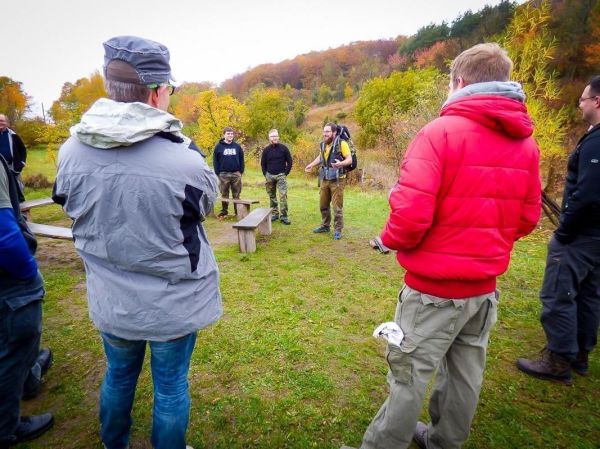 Ein Ausbilder erklärt Techniken im Freien, Teilnehmer hören aufmerksam zu