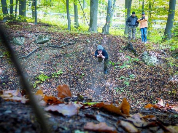 Ein Seil wird über einen Abhang gespannt, während eine Person daran schwingt