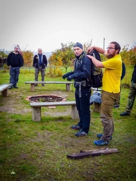 Ein Teilnehmer mit Rucksack erhält Anweisungen von einem anderen in gelber Kleidung