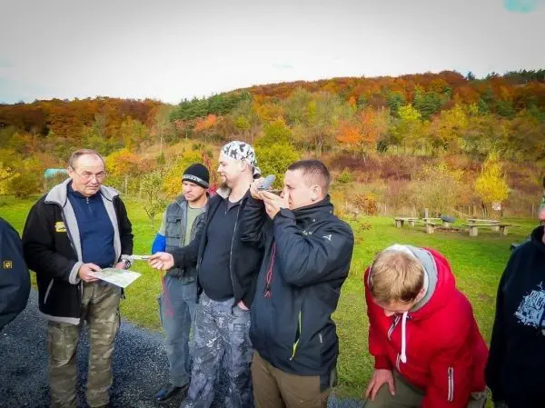 Gruppe betrachtet eine Karte und diskutiert Orientierungstechniken im Freien