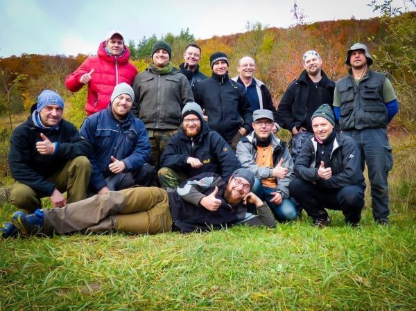 Gruppe von Personen posiert lächelnd auf einer Wiese in der Natur