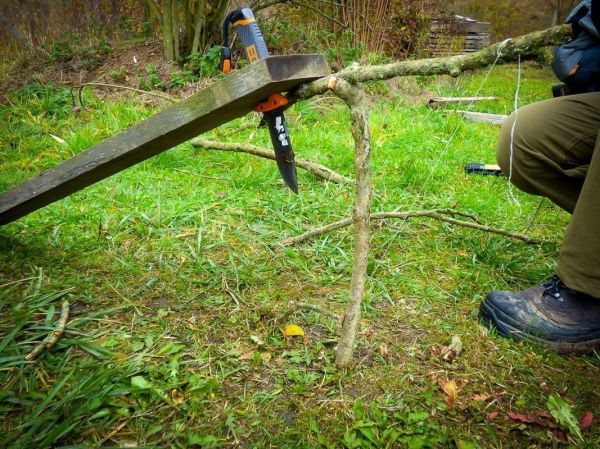 Holzstück wird mit einer Klappsäge bearbeitet, um eine Stütze zu formen