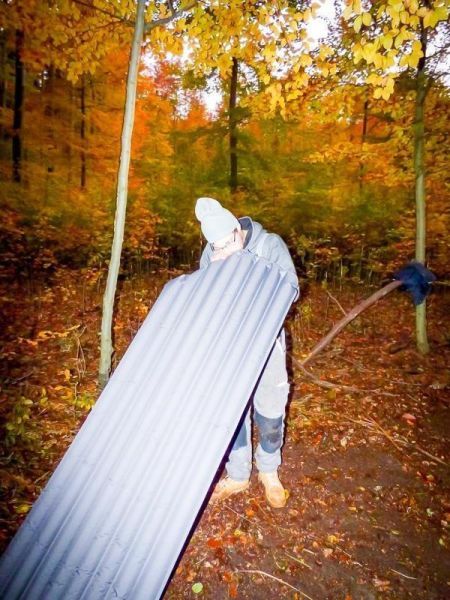 Isomatte wird im Wald auf den Boden gelegt