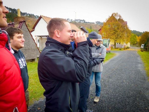 Mann hält Kamera und fotografiert eine ländliche Szene mit Häusern