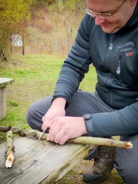 Messer bearbeitet Holzstück auf einer Holzoberfläche