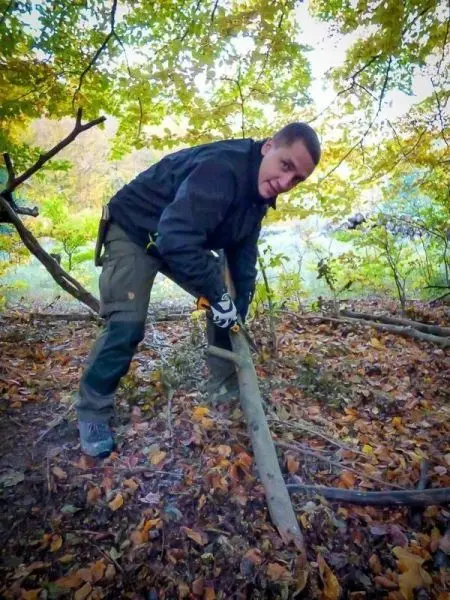Person hebt einen Stock im Wald an