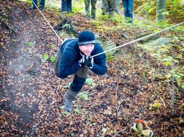 Person schwingt an einem Seil über einen Hang beim Überlebenstraining