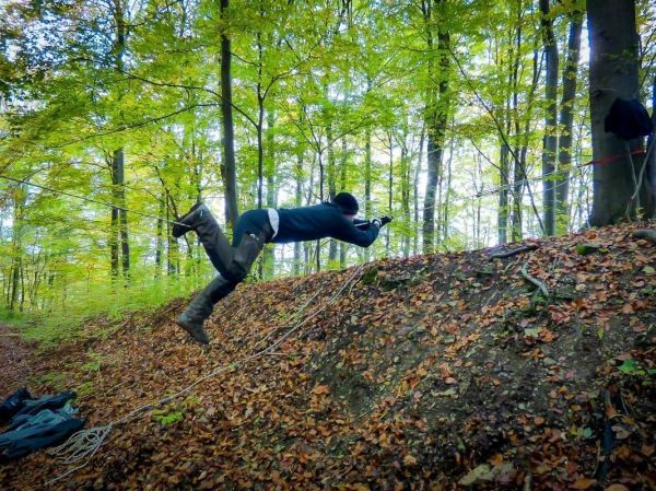 Person springt über eine Seilbrücke in einem Waldgebiet