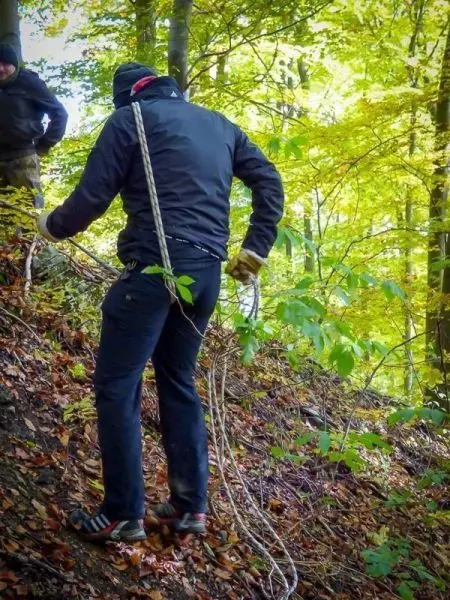 Person zieht Seil am Hang entlang