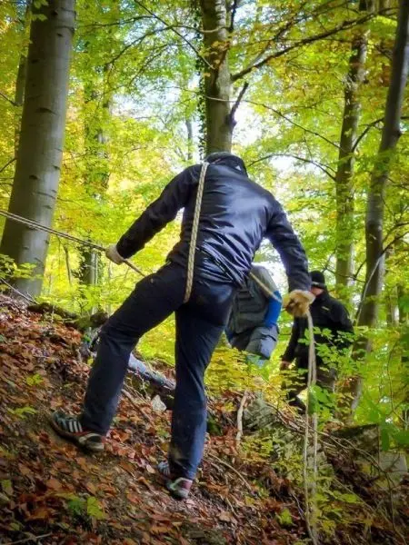 Person zieht sich an einem Seil einen Hang hinunter beim Überlebenstraining