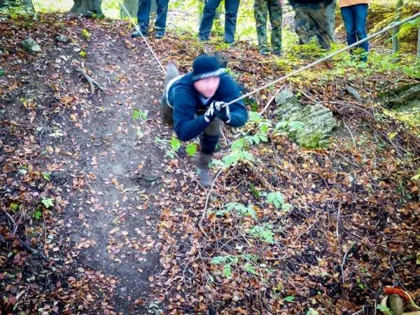 Person zieht sich an einem Seil einen Hang hinunter beim Überlebenstraining