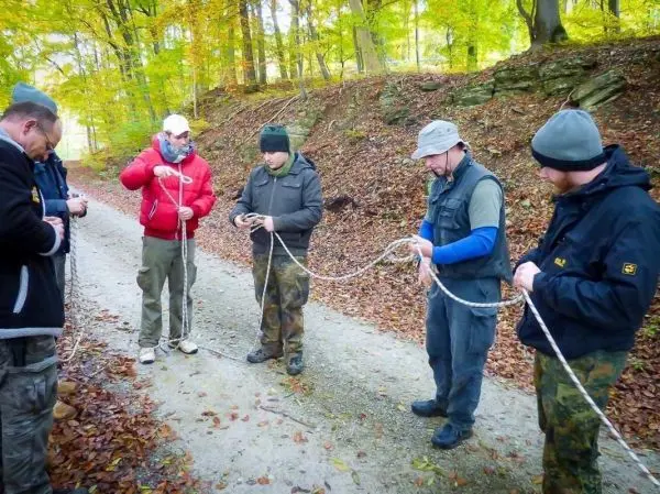 Sechs Personen üben den Umgang mit Seilen im Wald